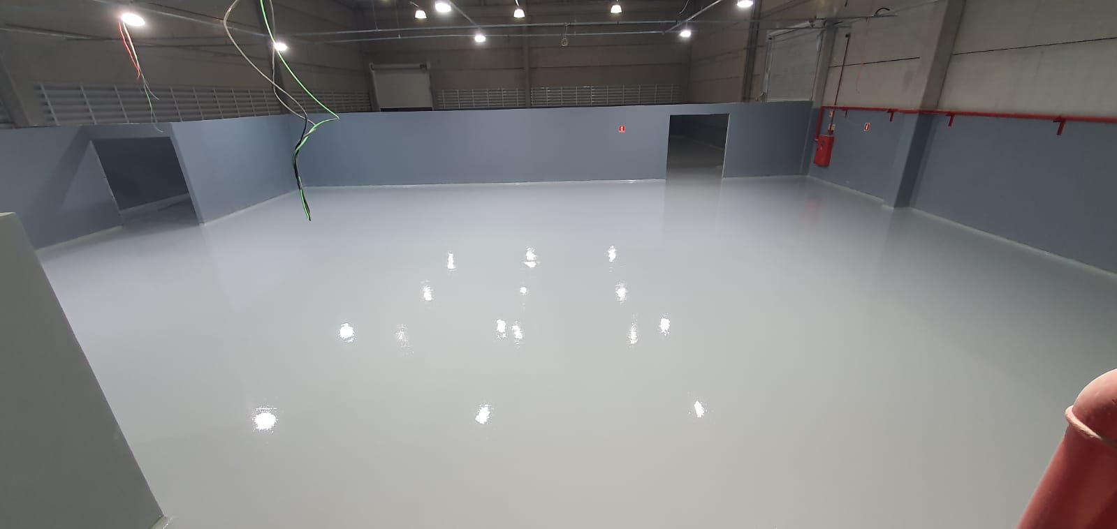 Trabalho da ColorGran: piso cinza pintado no interior de um galpão.